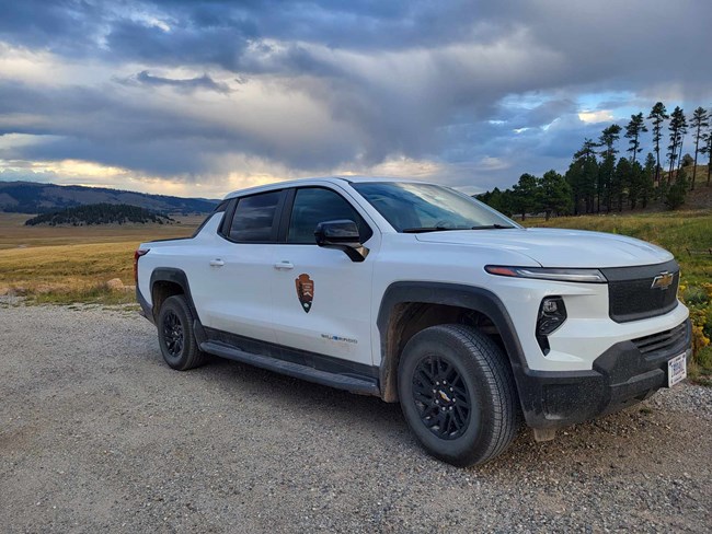 A white pickup truck with the National Park Service logo on the side.