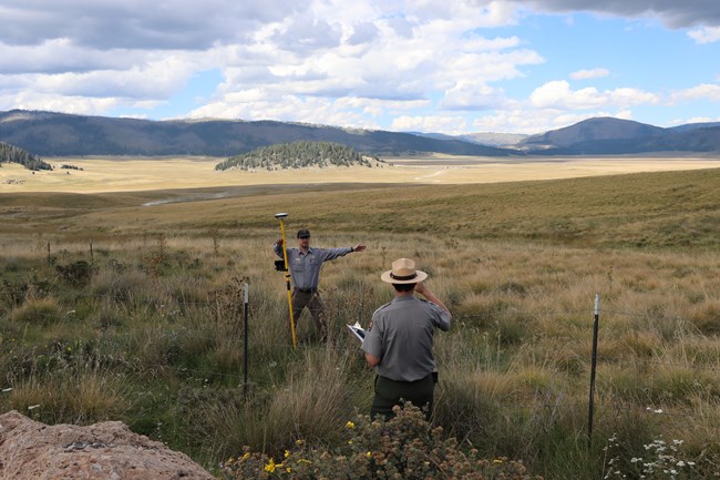 Two park rangers mark a location near the park entrance