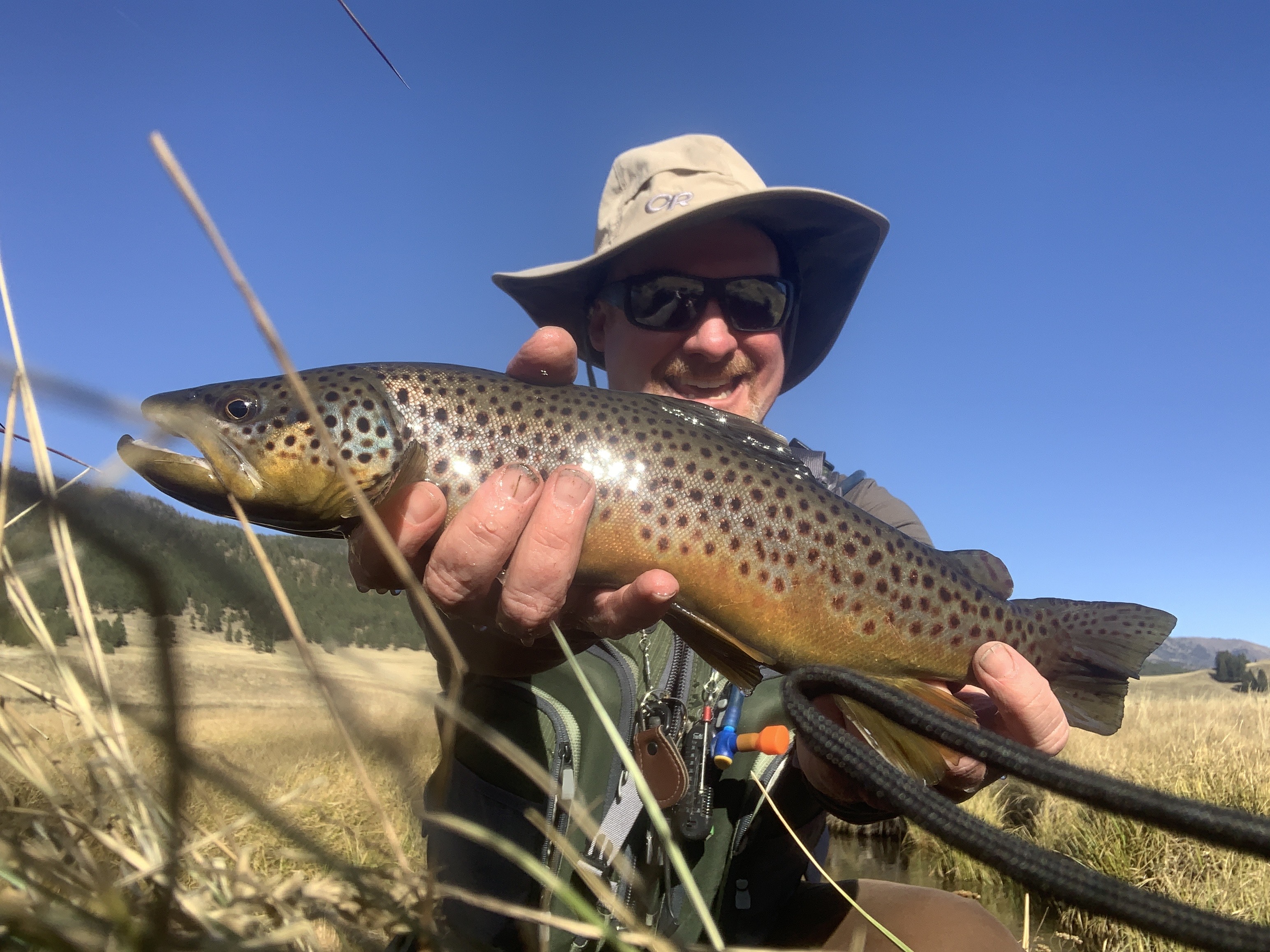 An angler holds up a large trout