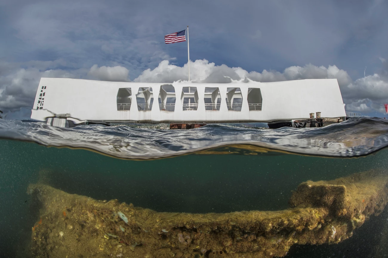 A view of the USS Arizona Memorial that also shows the wreckage of the USS Arizona under the waters of Pearl Harbor. A view of the USS Arizona Memorial that also shows the wreckage of the USS Arizona under the waters of Pearl Harbor.