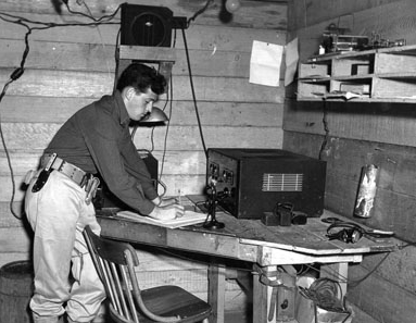 Pvt. Joseph Lockard, a young man leaning over a table that has electronic equipment.