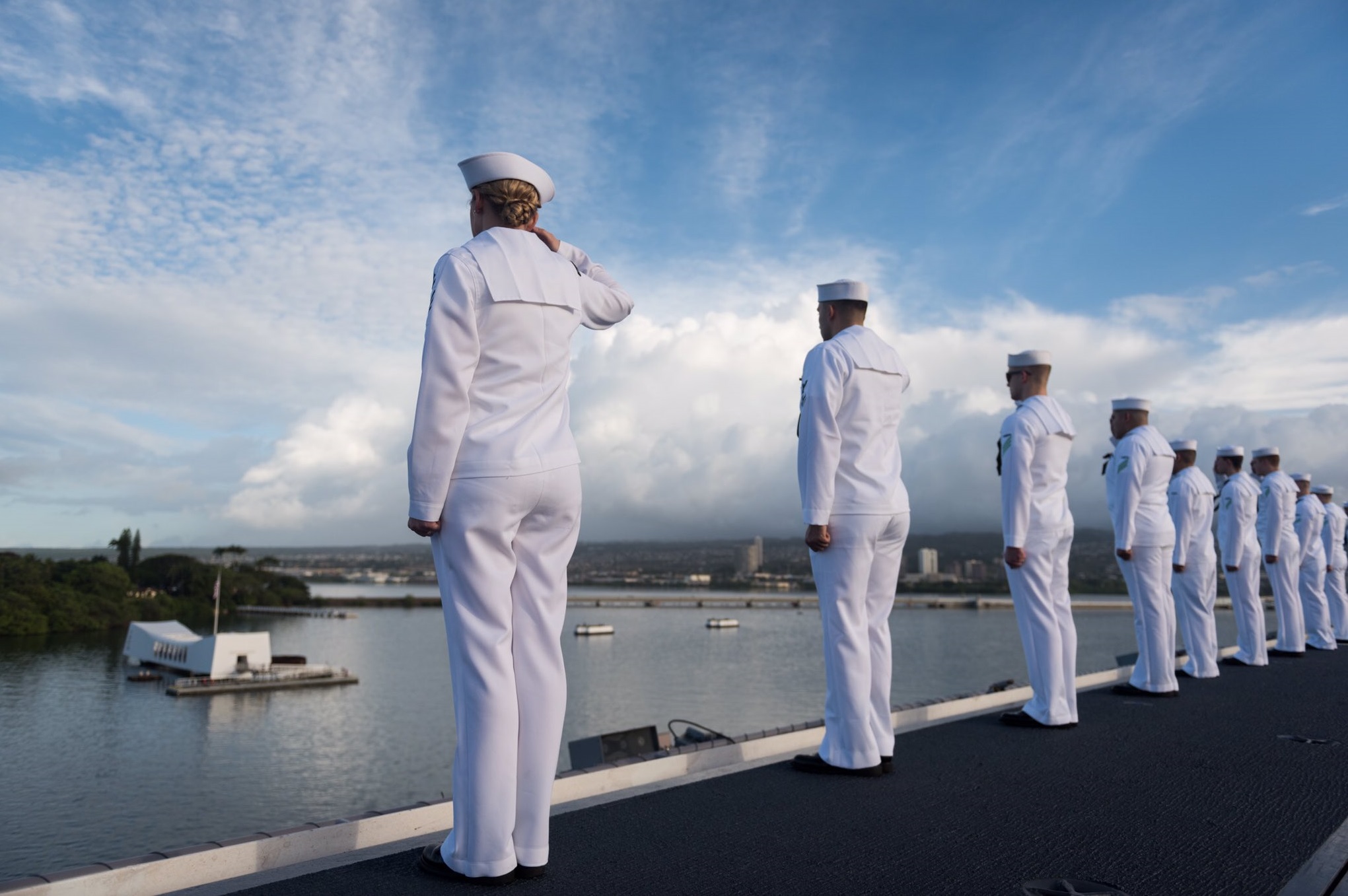US Navy sailors salute the USS Arizona