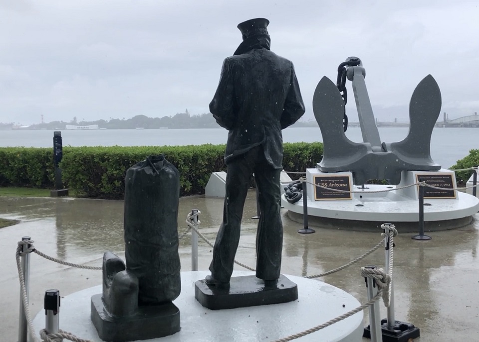 Stormy weather ahead for Pearl Harbor Rain falls on a gray statue of a lone navy sailor and a large anchor are
