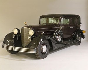 An automobile with gilt hood ornament.