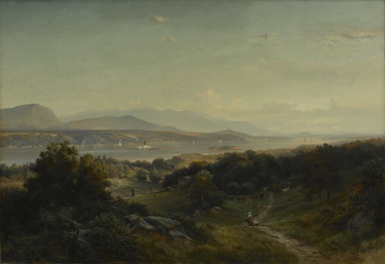 A landscape with river and mountains in the background.