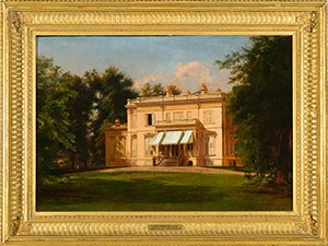 A pink stucco two-story house with central portico surrounded by lush trees.