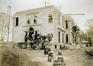 A group of men standing in front of a large building under construction.