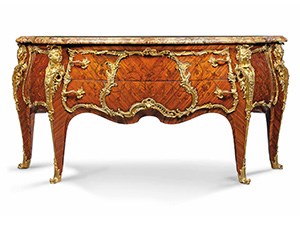A chest of drawers with marble top and gilt bronze decorative mounts.