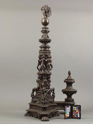 A large bronze sculpted andiron with enslaved figures in chains mounted around the base.