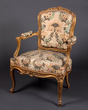 A gilt-wood chair upholstered with floral silk.