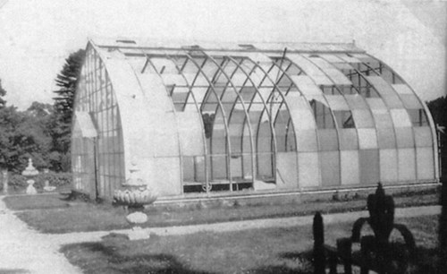 A greenhouse in disrepair with many glass panes missing.