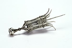 A silver cigar pierce in the form of a lantern.