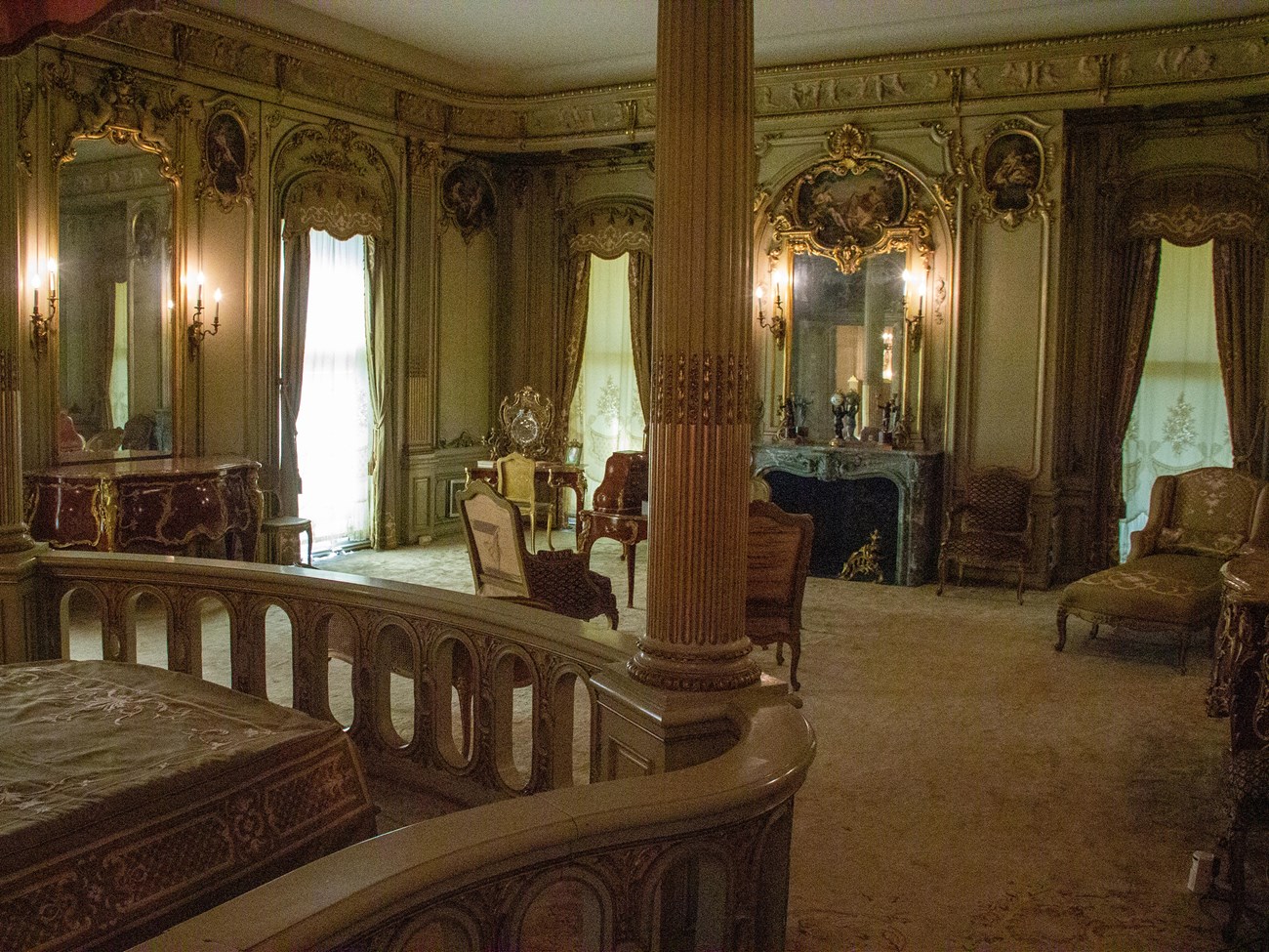 A grand bedroom with central fireplace and French gilt furnishings.