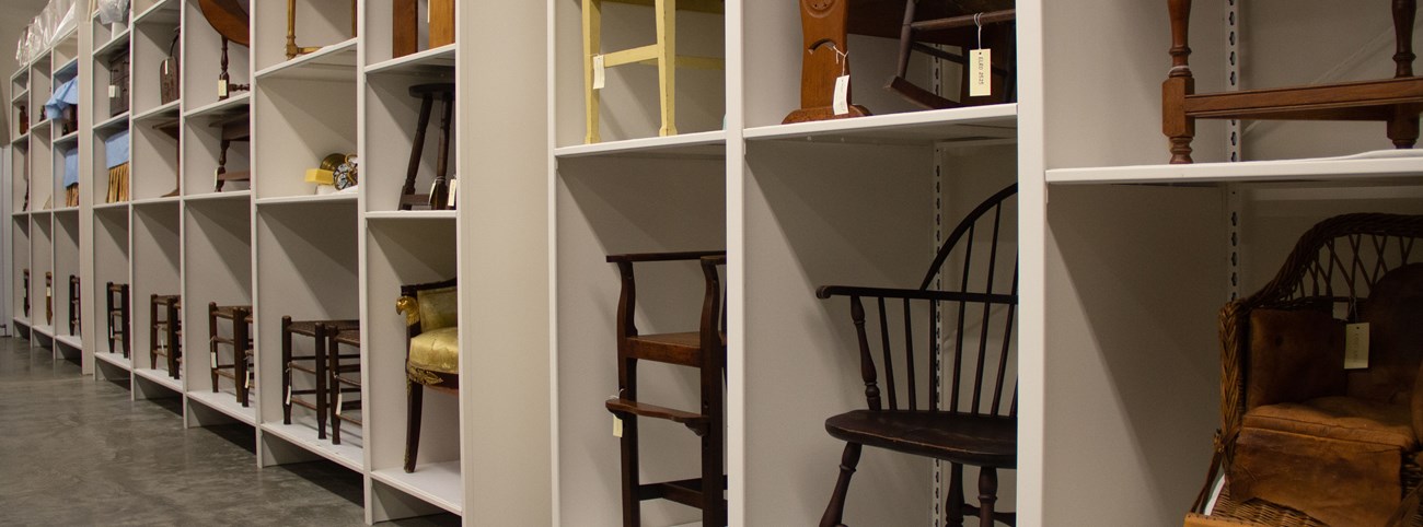 A wall of shelves with stored furniture.