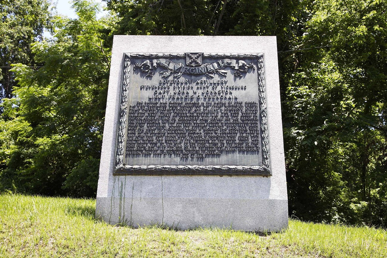 A large bronze plaque placed on a slanted slab of granite