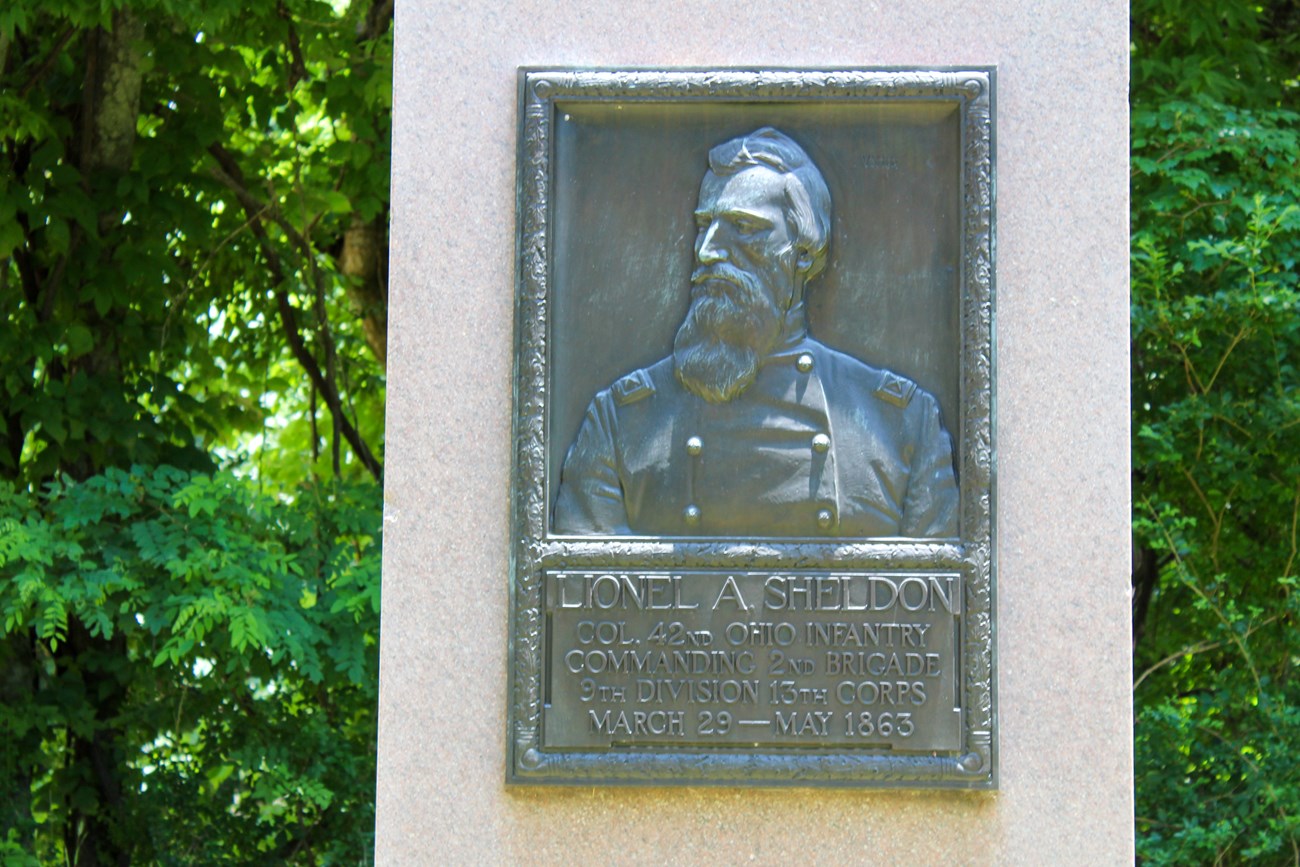 A bronzr relief portrait of a man dressed in uniform looking slightly to the side