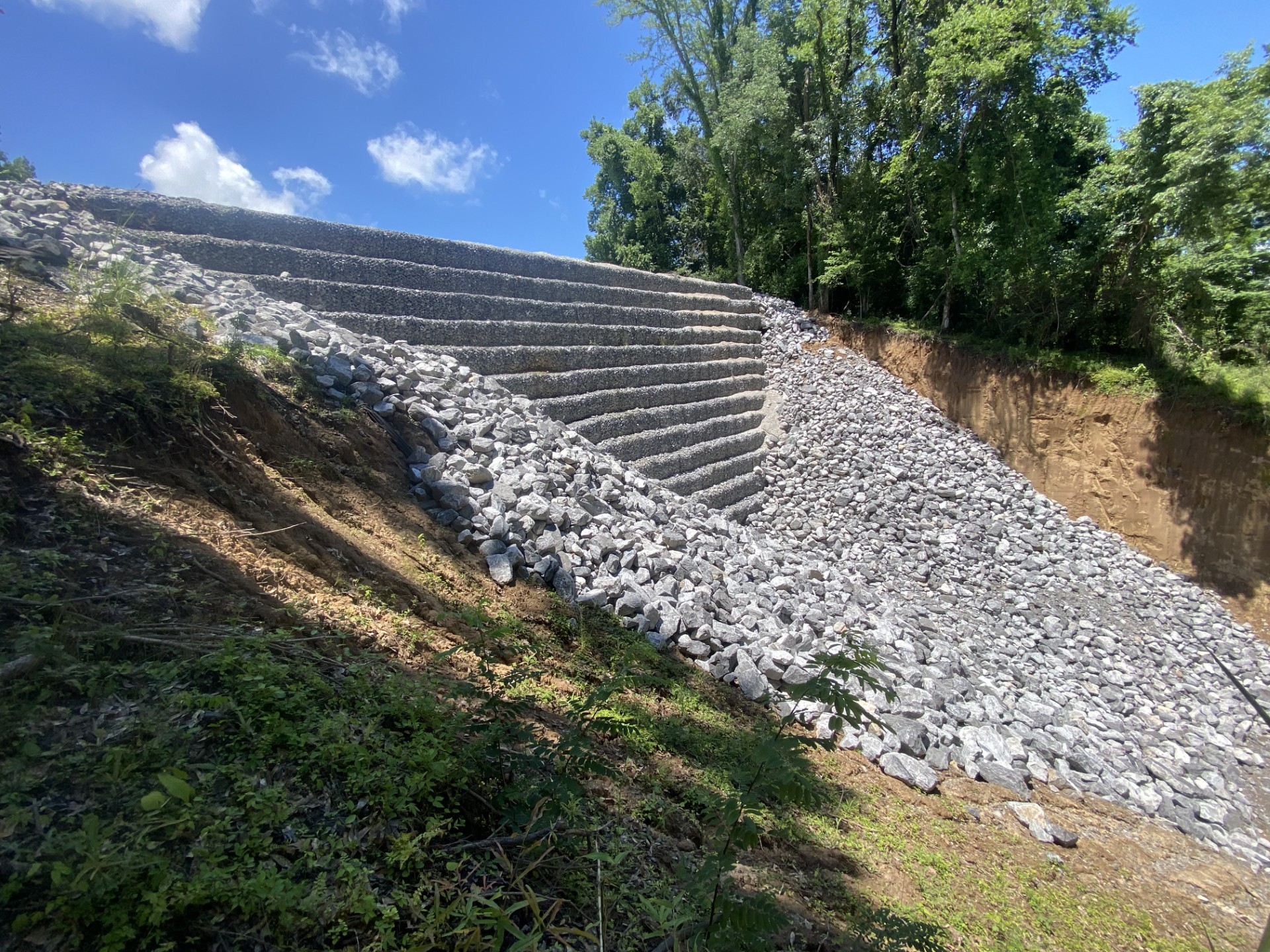 Very high wall made up of multiple levels of large wire oxes filled with large stones