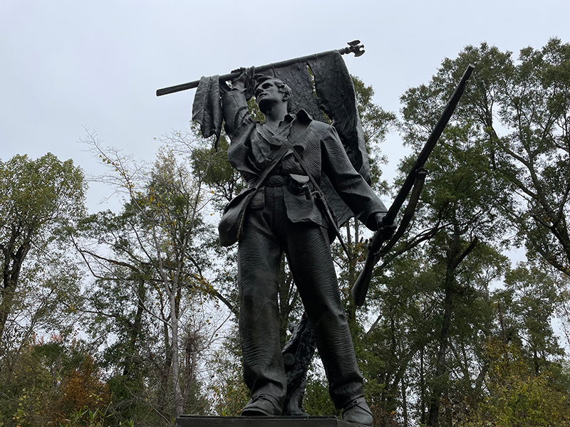Rhode Island Memorial Staute of Civil War soldier holding a tatter US flag. Statue is on a stone pedestal