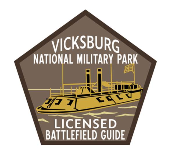 Pentagon shaped patch. Brown border with yellow ironclad in center on light brown background. text:  Vicksburg National Military Park. Licensed Battlefield Guide