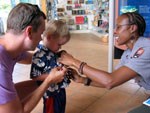 NPS Ranger pins a Junior Ranger badge on a boy while his father helps