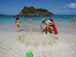 sand castles in a circle on the beach at Trunk Bay, with an island offshore in the background