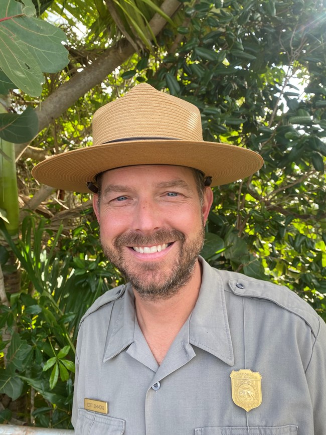 Deputy Superintendent Scott Simmons smiles in front of Tire Palm and other Virgin Islands flora
