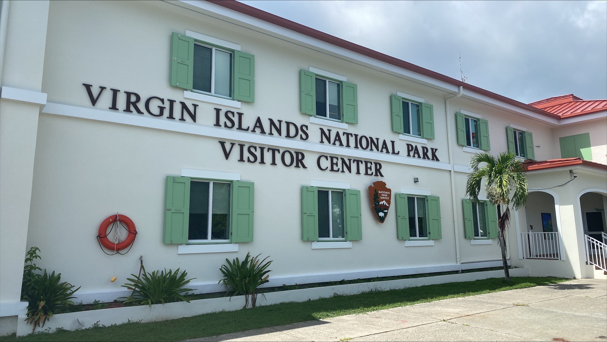 VCimage Image of the Virgin Islands National Park Visitor center building with green shutters and the NPS arrowhead.