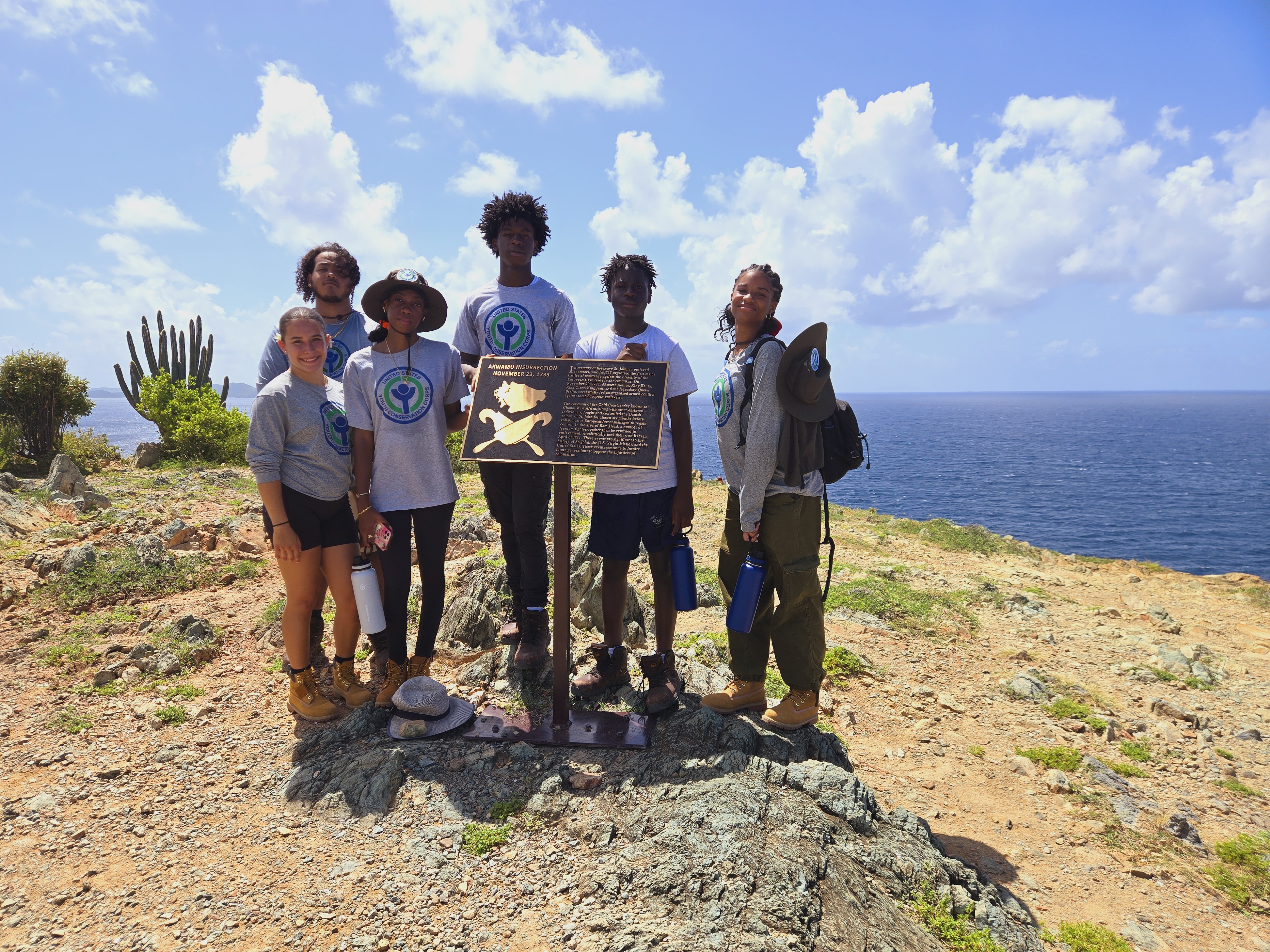 2024 YCC Youth at Ram Head Summer Youth Group on a sandy hill top with the ocean in the background