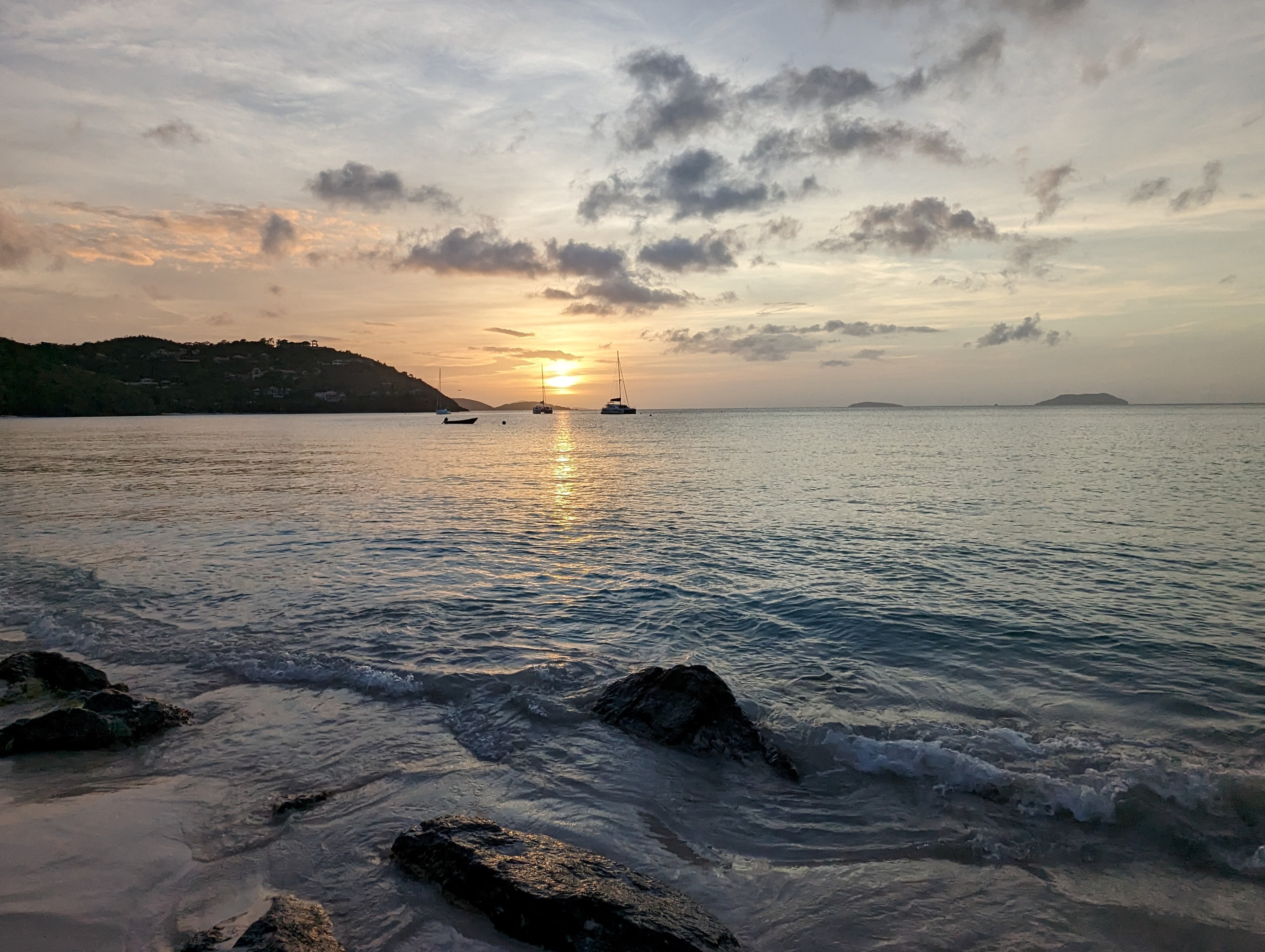 Sunset at Cinnamon Bay. Image of the beach at Cinnamon Bay at sunset with boats in the distance.