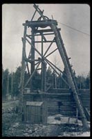 Historic photo showing a mine shaft made from timbers.