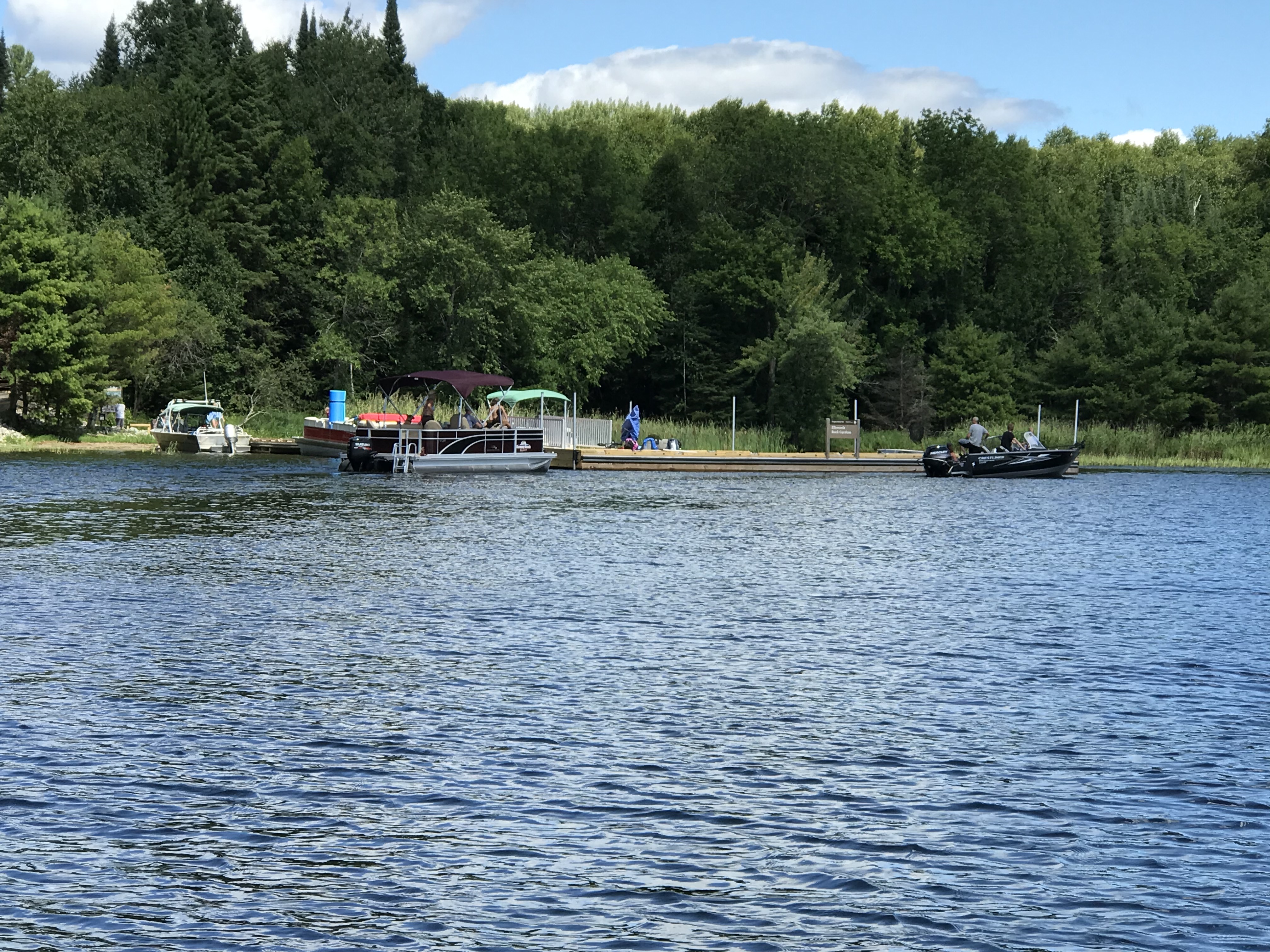A long wooden dock with multiple boats attached.
