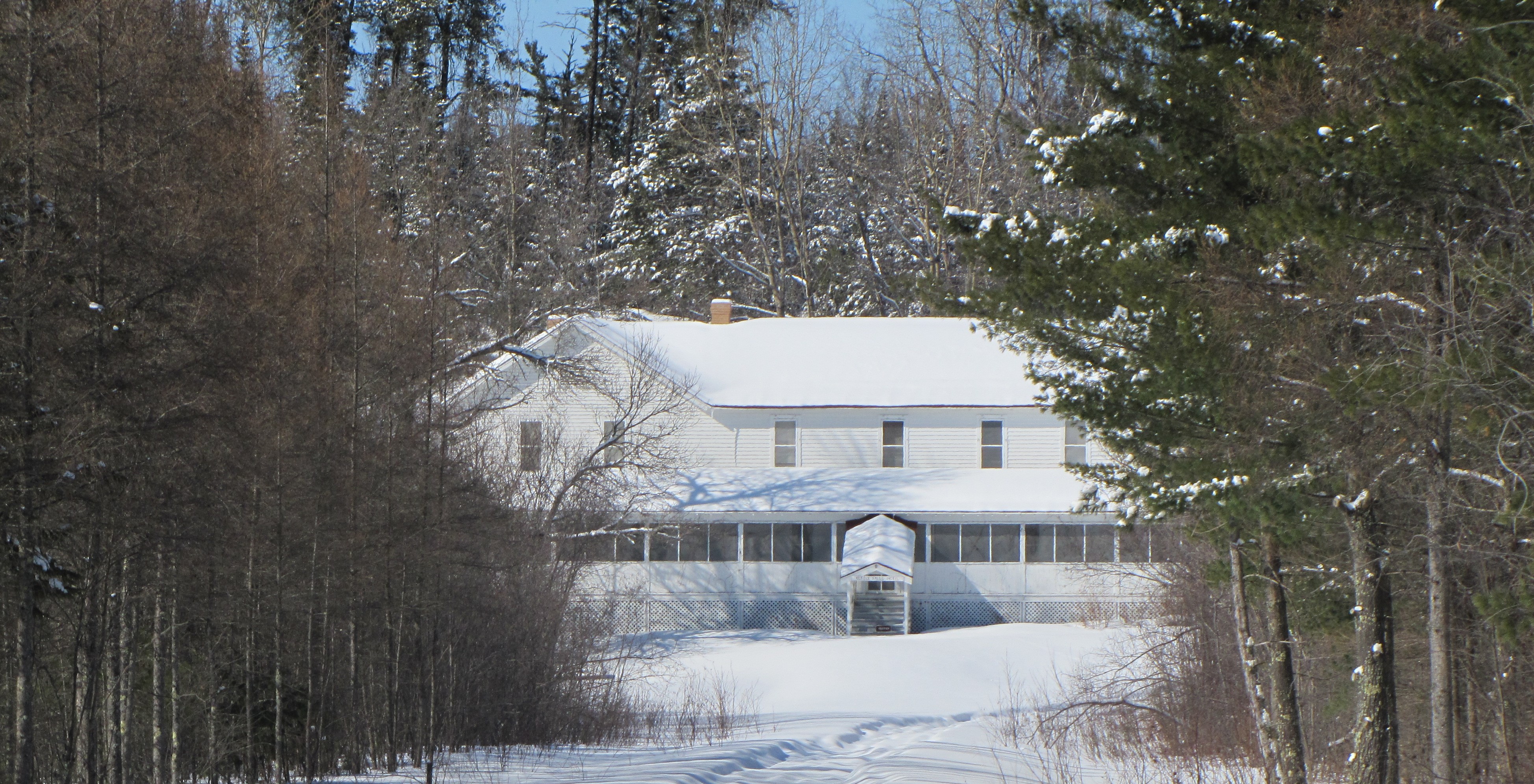 A snow covered hotel and landscape in winter.