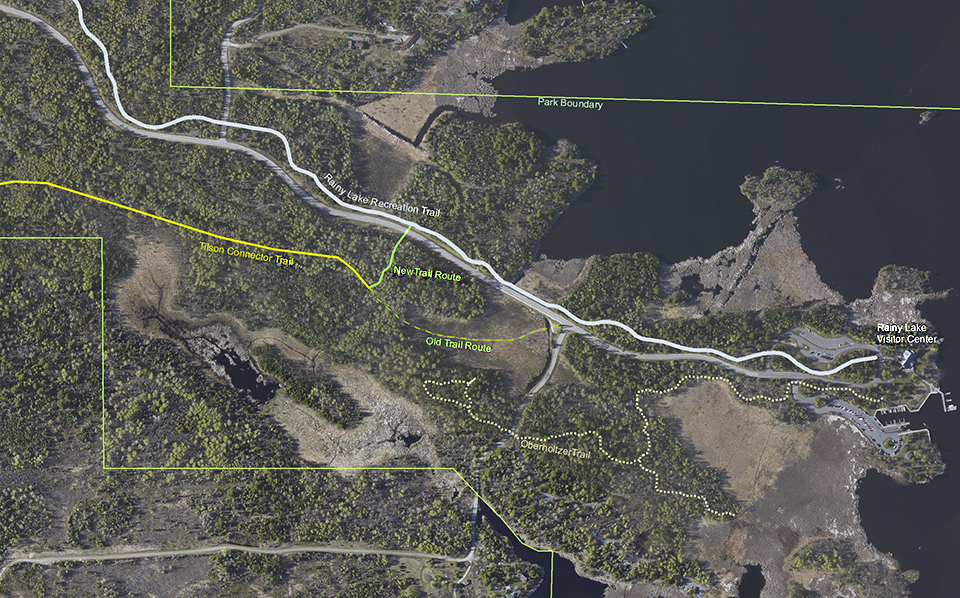 An aerial photograph of the Rainy Lake Visitor Center and its surrounding trail systems. In one section the Rainy Lake Recreation Trail (shown as a white line) connects to the Tilson Connector Trail (shown as a yellow line) by a new trail shown in green.
