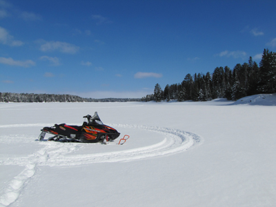 Snowmobile sitting on the frozen lake surface
