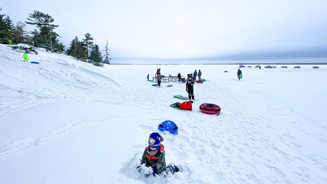 Kids and adults playing at a sledding hill