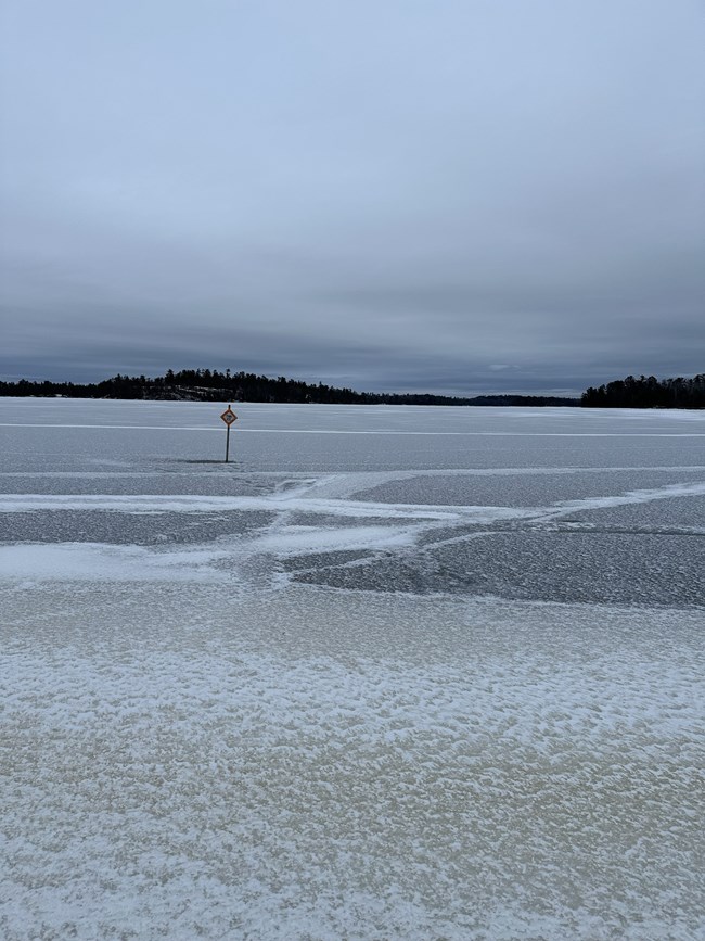 A frozen lake and a cautionary sign saying Thin Ice