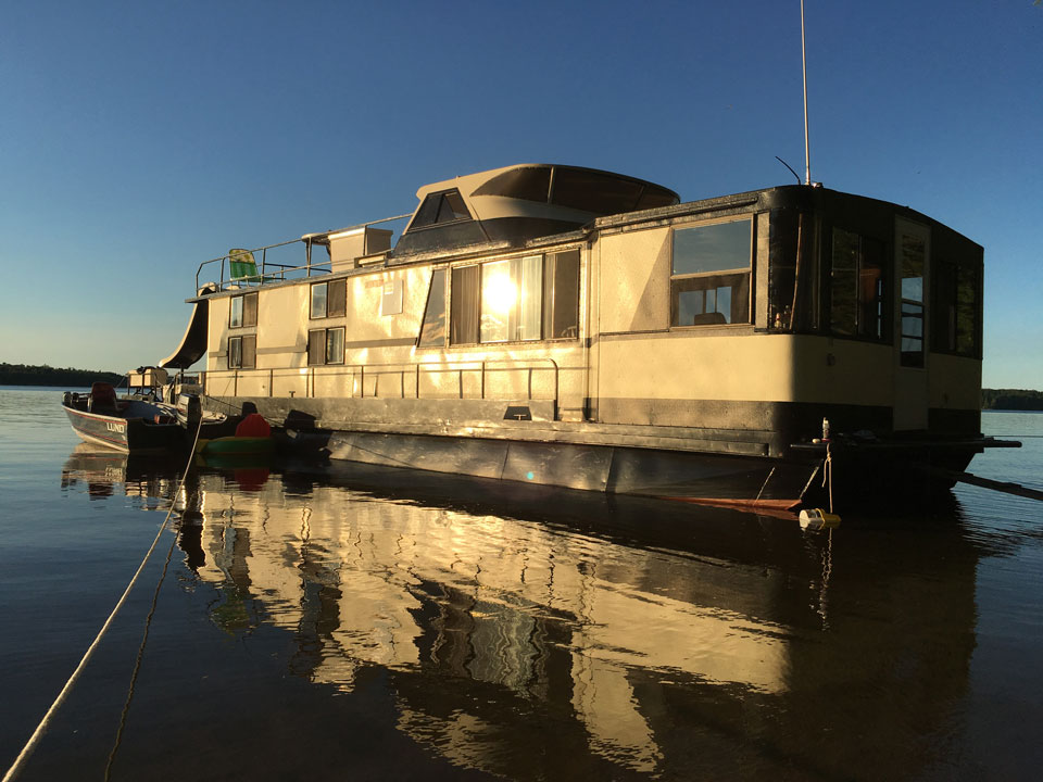 Houseboat moored at a overnight site in Voyageurs National Park. Houseboat with sunset hitting the side of it