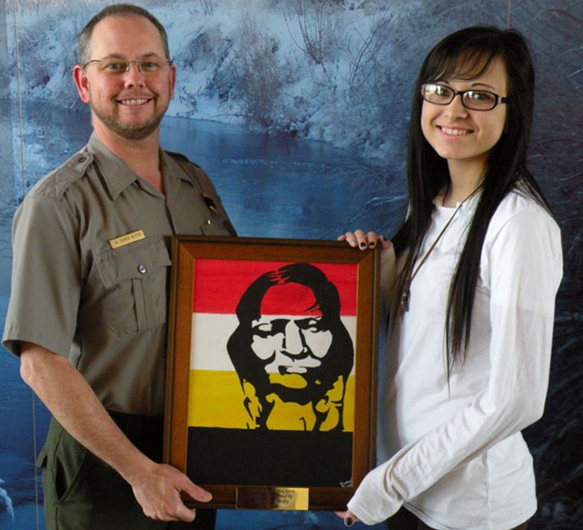 Rachael Shockley, a junior at Elk City High School, donates her painting of Cheyenne Peace Chief Black Kettle to Washita Battlefield NHS.  She is shown here with Park Superintendent, M. Tucker Blythe.
