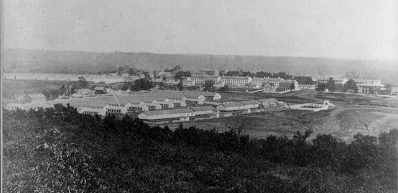 Fort Leavenworth Kansas, 1867, shows a neat row of barracks nestled at the bottom of a hill in a valley on the Great Plains.