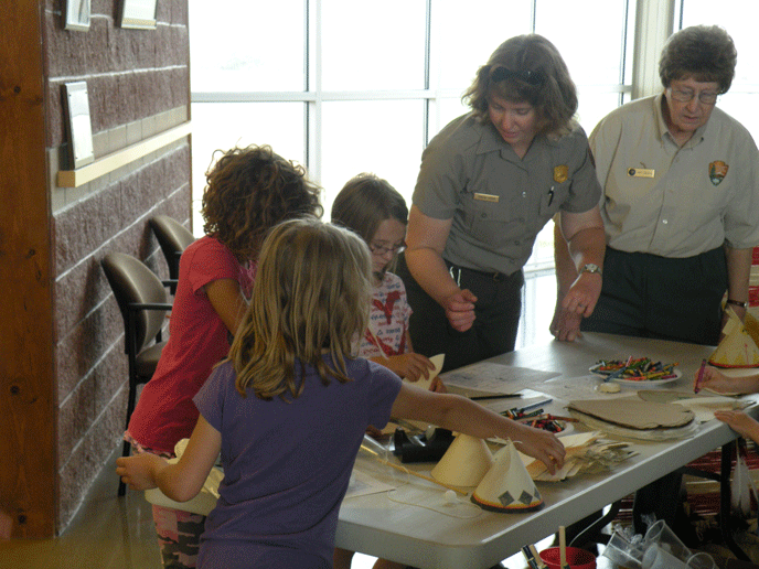 Park Guide Karena Minor and volunteer Kay Caudle assisting Jr. Rangers in decorating their paper tipis 4-21-15