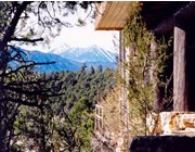 Snow-covered peaks framed by visitor center and pines.