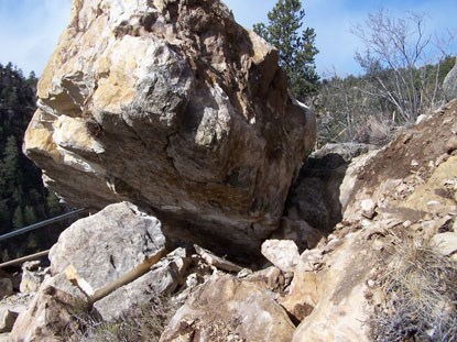 A multi-ton boulder fallen against handrail