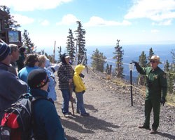 A ranger talks to visitors on mountaintop.