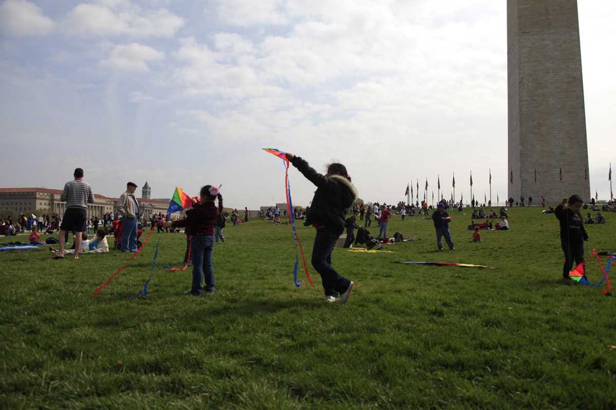 Children flying kites at the Washington Monument during the National Cherry Blossom Festival.