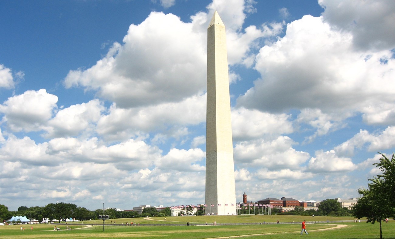 Washington Monument against a blue sky with white puffy clouds