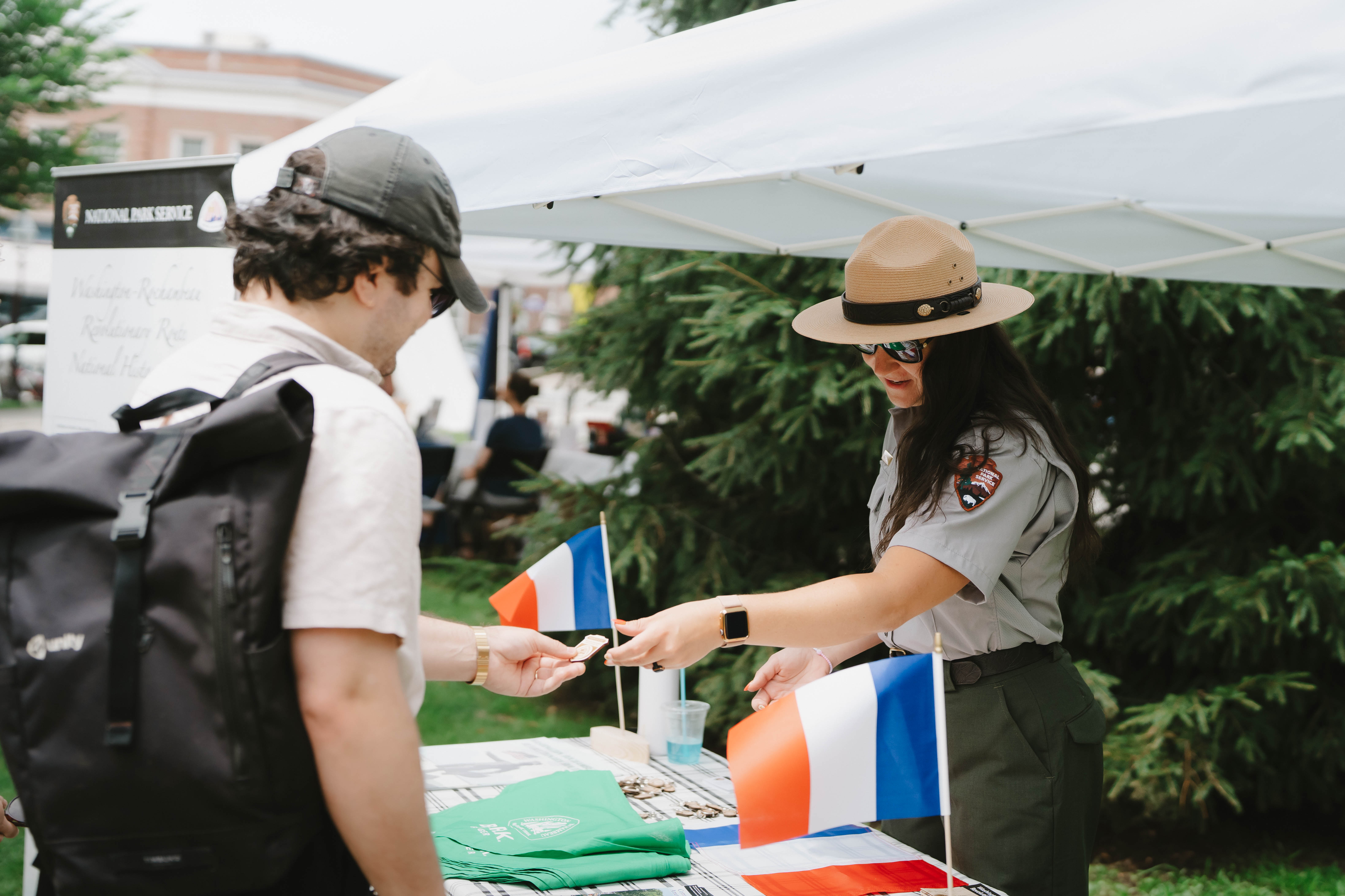 Visitors receive information from a National Park Service ranger at a Washington-Rochambeau National Historic Trail outreach table.