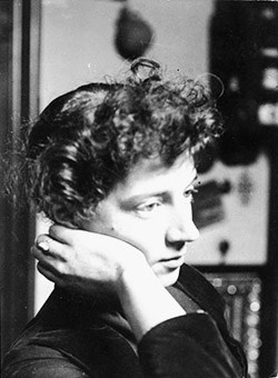 A black and white photo of a young women, head resting on her hand.