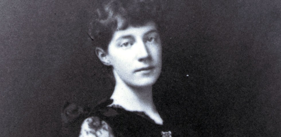 A black and white photo of a young women sitting.