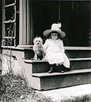 Historic Black and White Photo of a little girl and dog seated on the steps of the Weir House