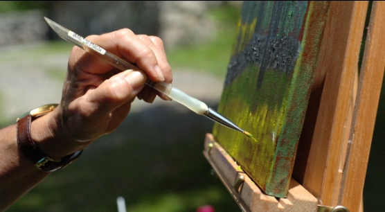 An artists paints outdoors in Weir Farm National Historic Site's landscape.